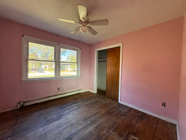 a view of room with window ceiling fan and hardwood floor