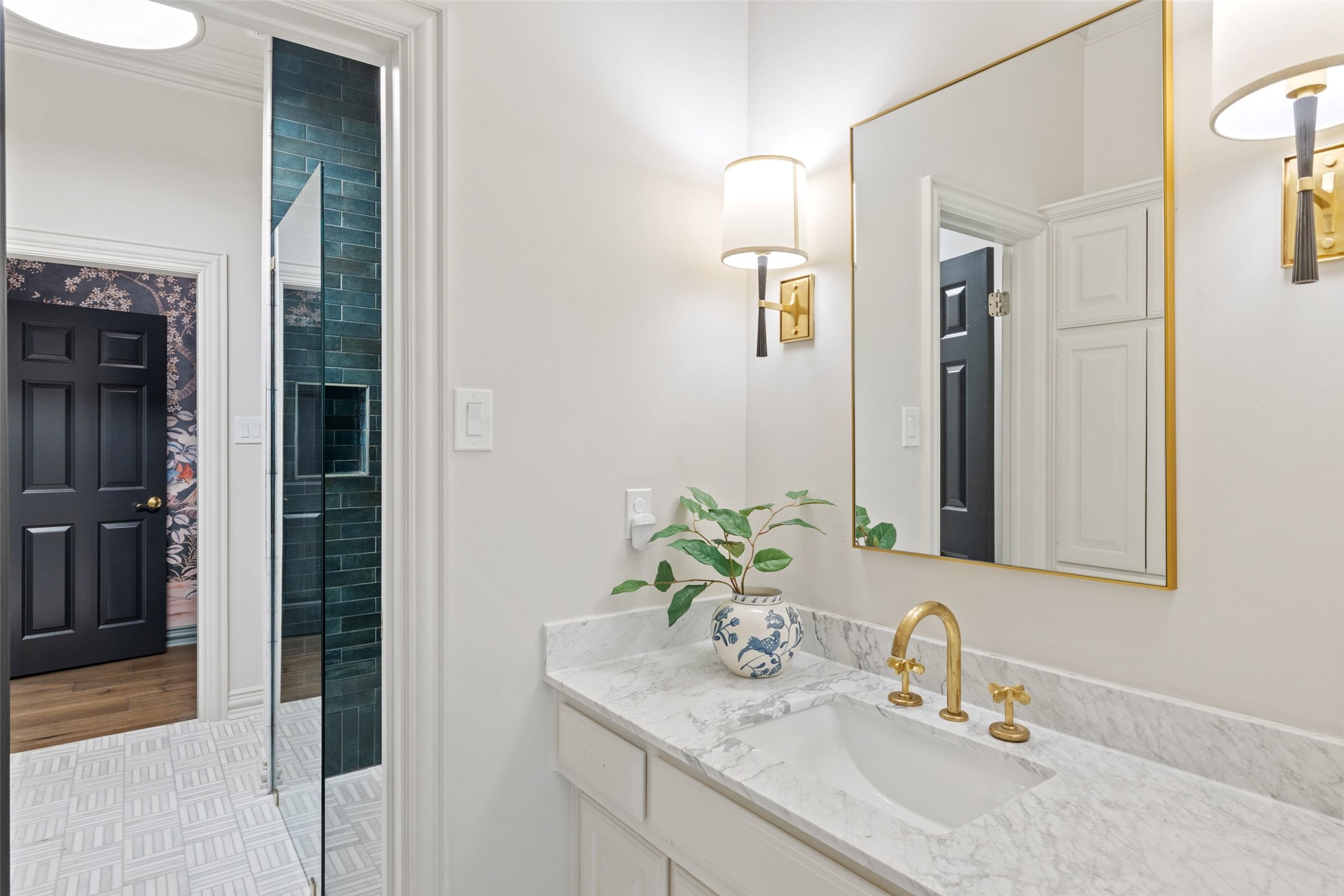 4201 Green Cliffs Road Austin, TX 78746 - Photo 22 of 40 This main floor bath includes beautiful tile work, warm sconce lighting, and a walk-in shower for effortless guest convenience