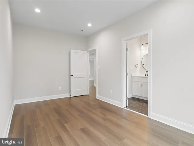 a kitchen with stainless steel appliances kitchen island granite countertop a stove a sink and white cabinets with wooden floor