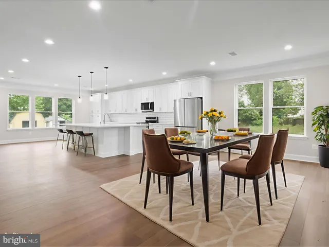 a kitchen with stainless steel appliances kitchen island granite countertop a sink a stove a microwave and a refrigerator