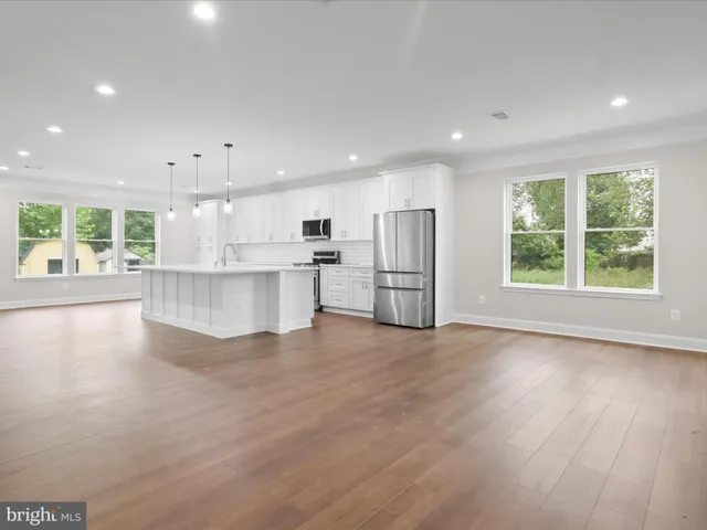a view of a big room with wooden floor fireplace and windows