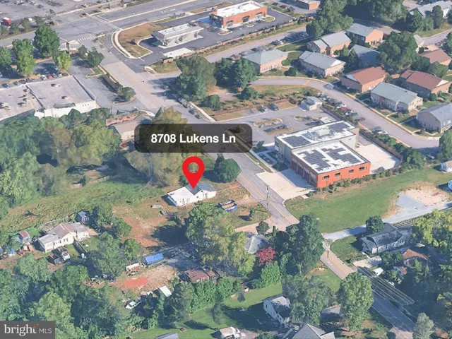 a view of a house with a big yard and large trees