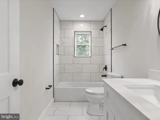 a bathroom with a double vanity sink a toilet a mirror and shower