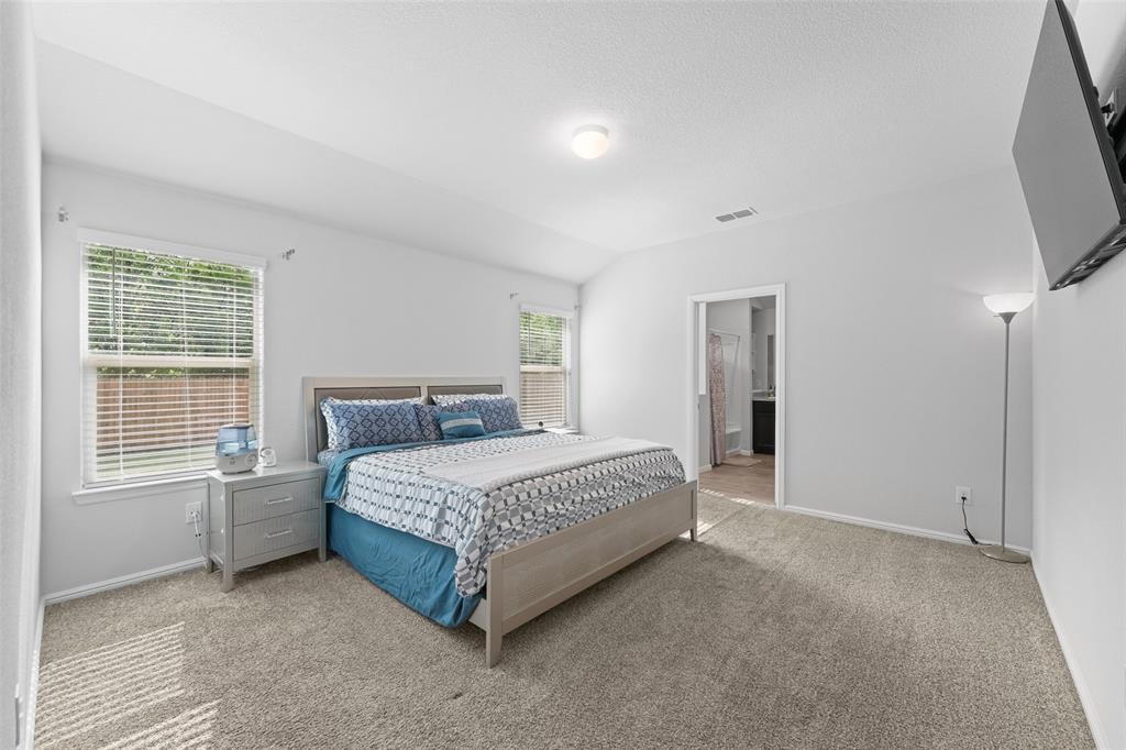 9020 Ridgeriver Way Fort Worth, TX 76131 - Photo 14 of 26 a spacious bedroom with a bed and a flat screen tv
