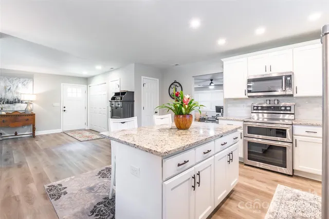 a kitchen with stainless steel appliances granite countertop a sink stove and refrigerator