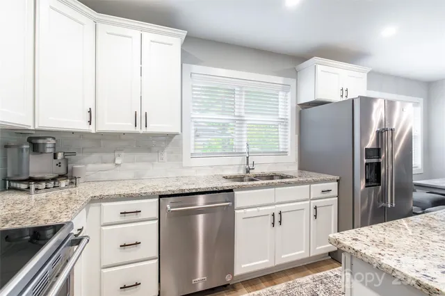 a kitchen with stainless steel appliances granite countertop a sink stove and refrigerator