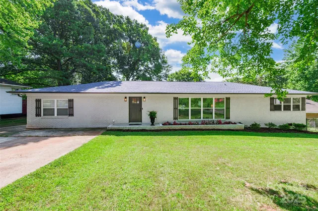 a view of a house with a yard and a patio