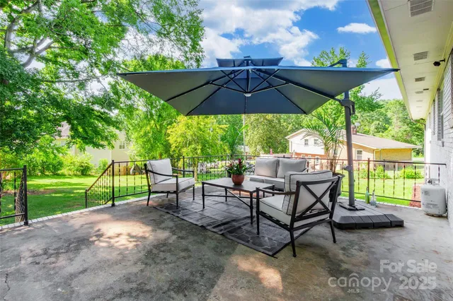 a view of a patio with table and chairs under an umbrella