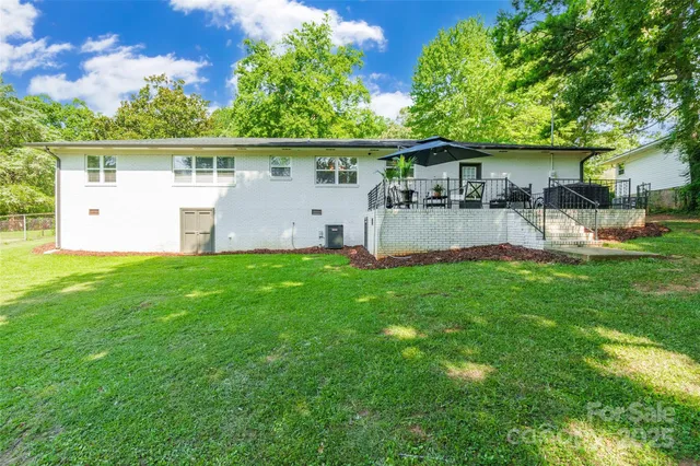 a view of a house with a yard deck and a patio