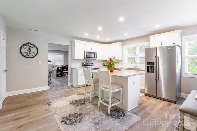 a kitchen with stainless steel appliances a refrigerator and a stove top oven