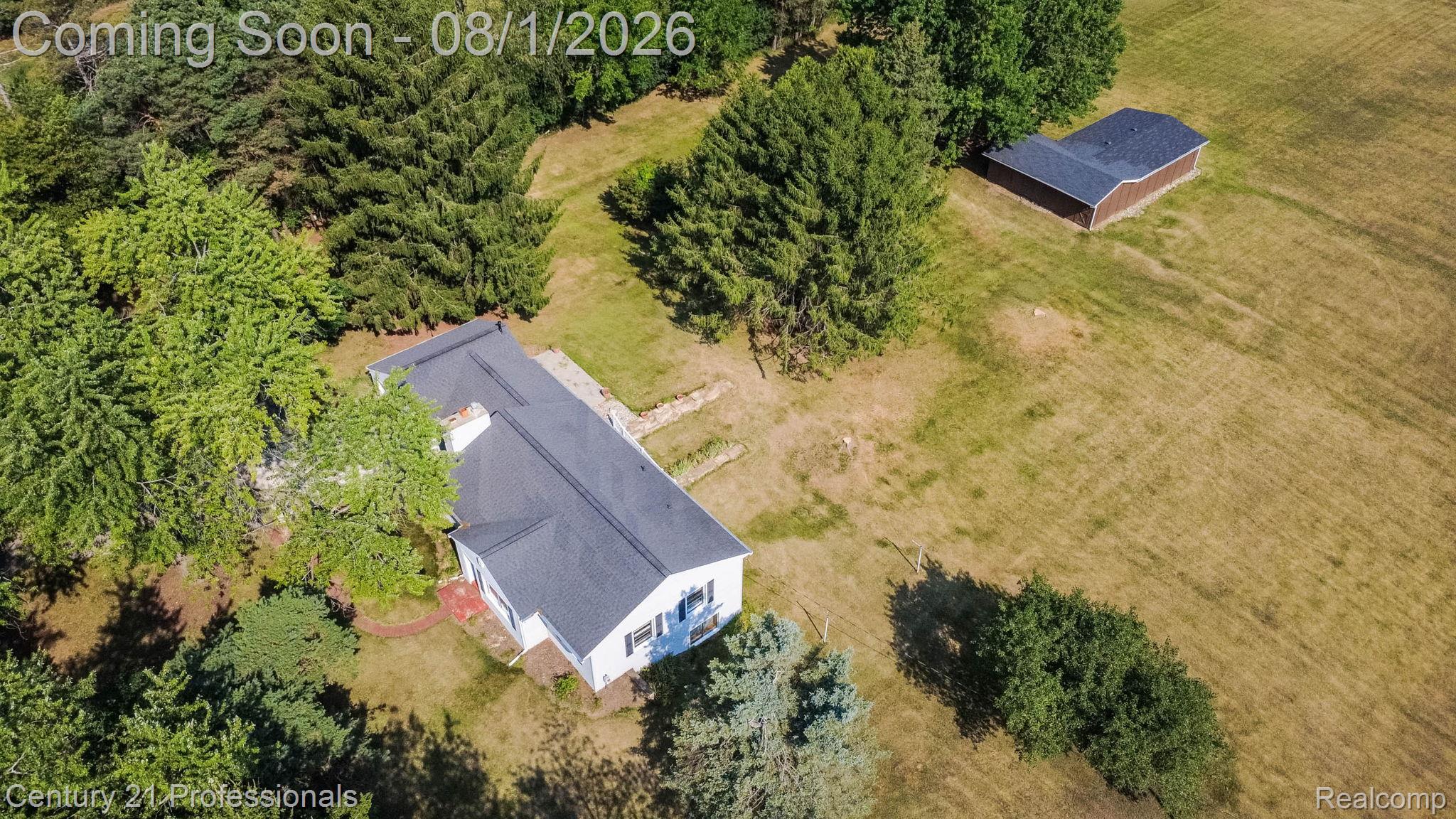 1365 East Buell Road Rochester, MI 48306 - Photo 43 of 56 Sprawling property featuring a white exterior residence with a dark shingle roof, surrounded by mature trees and expansive open fields