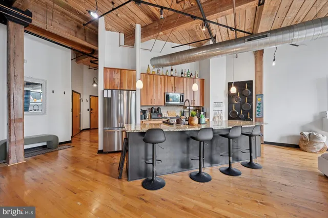 a view of living room kitchen and dining area with wooden floor