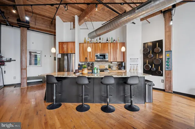 a kitchen with a sink appliances and wooden floor