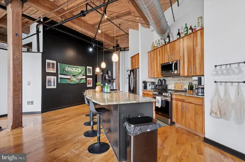 a kitchen with kitchen island a counter top space a sink a refrigerator and a stove