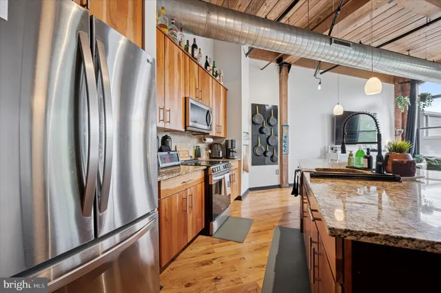 a kitchen with stainless steel appliances granite countertop a refrigerator a stove and a sink