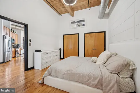 a bedroom with a large bed and wooden floor