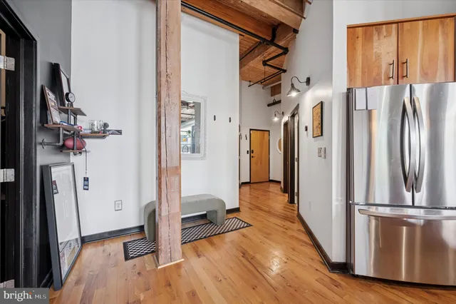 a view of hallway with furniture and a refrigerator