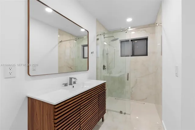 a bathroom with a sink a mirror and a shower