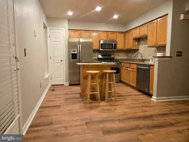 a kitchen with stainless steel appliances granite countertop a refrigerator a stove top oven a sink and dishwasher