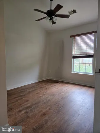 an empty room with windows and fan