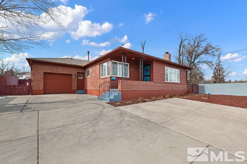 1051 Keystone Avenue Reno, NV 89503 - Photo 1 of 25 a front view of a house with a yard and garage
