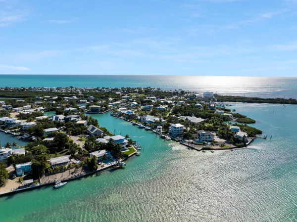 a dining room with furniture large windows and wooden floor