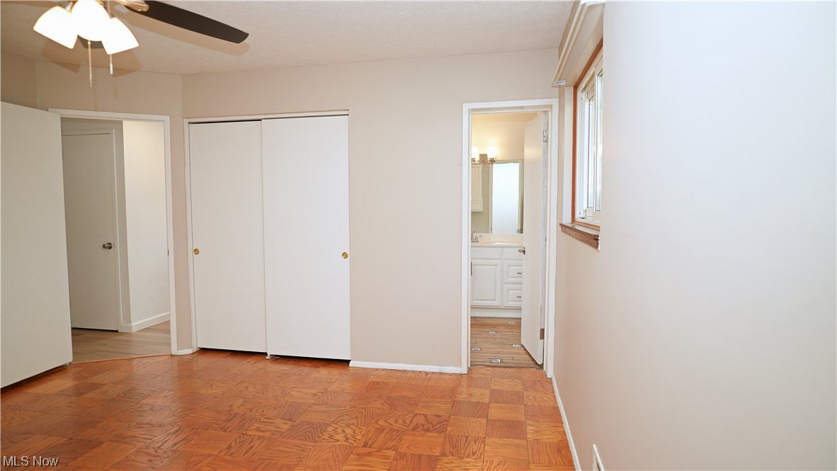 6676 Rochelle Boulevard Parma Heights, OH 44130 - Photo 12 of 21 Unfurnished bedroom featuring light parquet flooring, a closet, ensuite bath, and ceiling fan