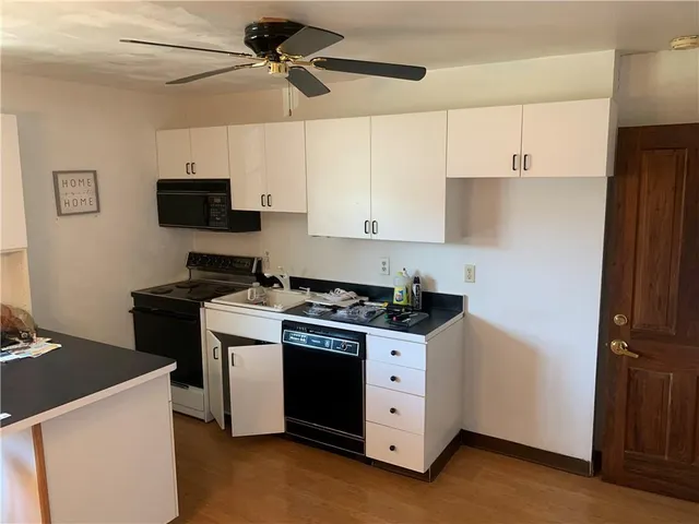 a kitchen with stainless steel appliances a stove a refrigerator a sink a microwave and cabinets