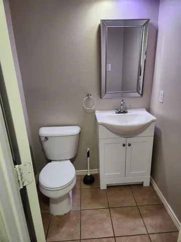 a bathroom with a toilet sink and mirror