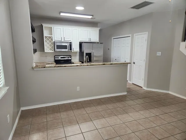 a kitchen with stainless steel appliances a refrigerator sink and microwave