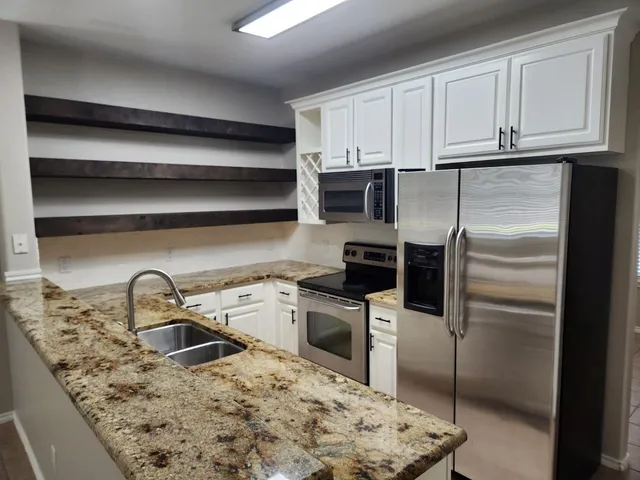 a kitchen with a sink a refrigerator and cabinets