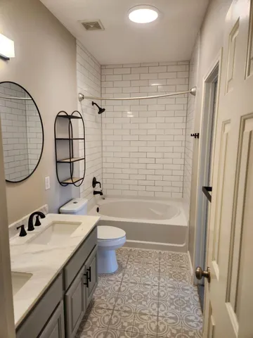 a bathroom with a sink a toilet and a mirror