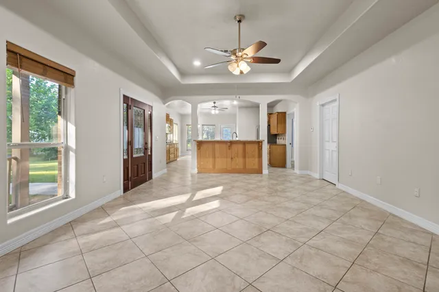 a spacious bathroom with a granite countertop sink a mirror and a bathtub
