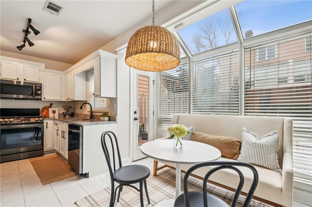 7500 Roswell Road, Unit 24 Sandy Springs, GA 30350 - Photo 9 of 45 a kitchen with stainless steel appliances granite countertop a dining table chairs and a refrigerator