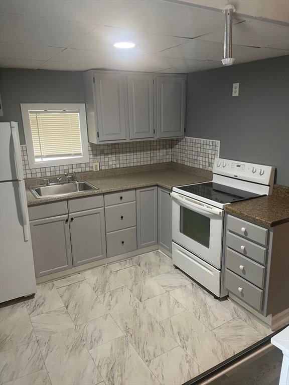a kitchen with sink stove and cabinets