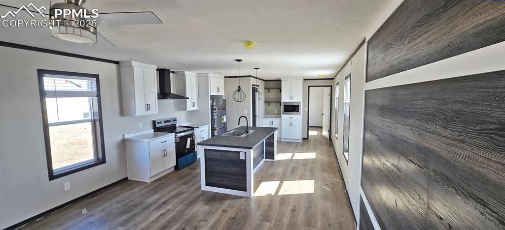 7075 North Ramah Highway Yoder, CO 80864 - Photo 5 of 13 a kitchen with stainless steel appliances granite countertop a refrigerator a sink dishwasher a stove and white countertops with wooden floor