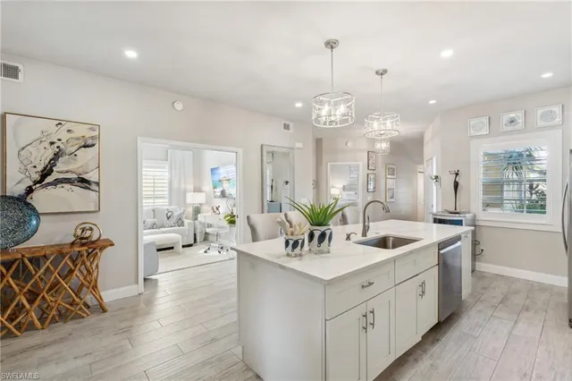 a large white kitchen with a large window and stainless steel appliances