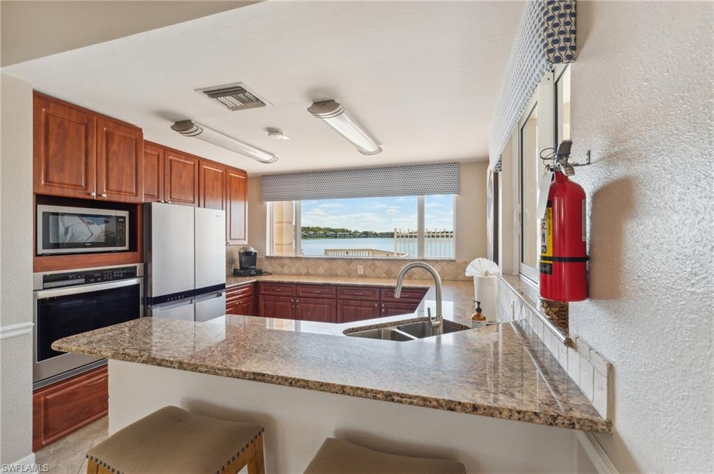 1747 Reuven Circle, Unit 1703 Naples, FL 34112 - Photo 26 of 31 a kitchen with stainless steel appliances granite countertop a sink and cabinets