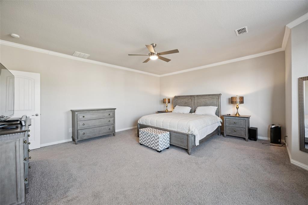1701 Long Meadow Road Wylie, TX 75098 - Photo 14 of 30 a spacious bedroom with a bed and a ceiling fan