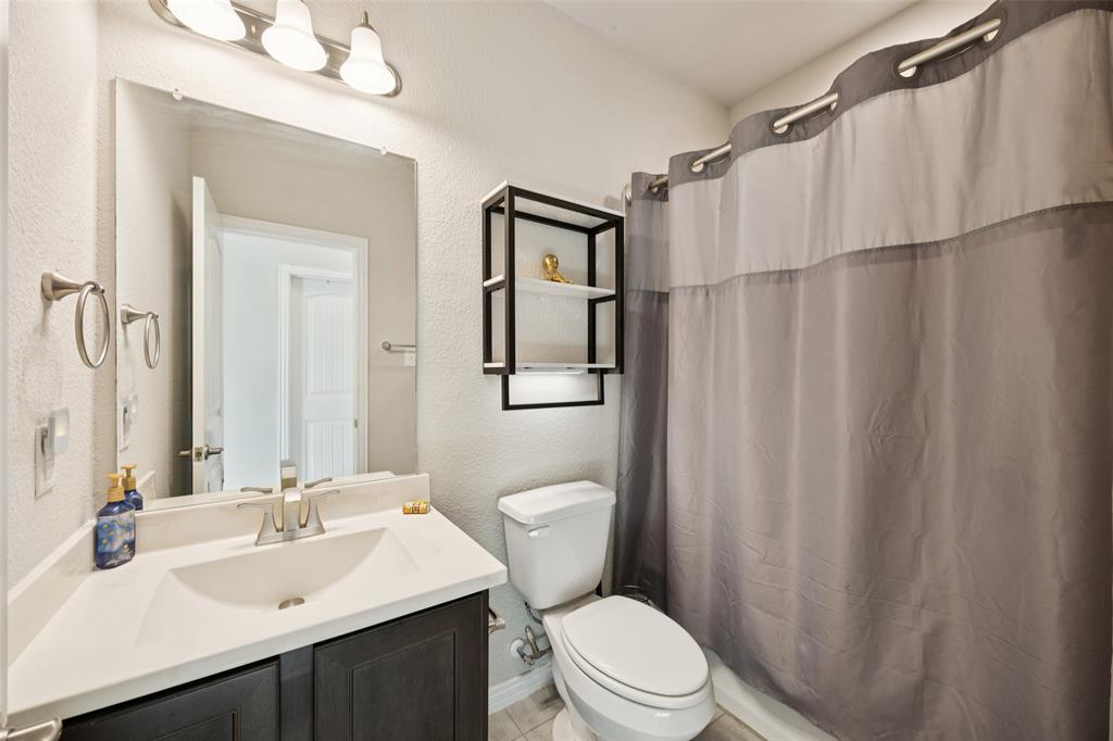 1701 Long Meadow Road Wylie, TX 75098 - Photo 20 of 30 a bathroom with a sink a toilet a mirror and shower curtain