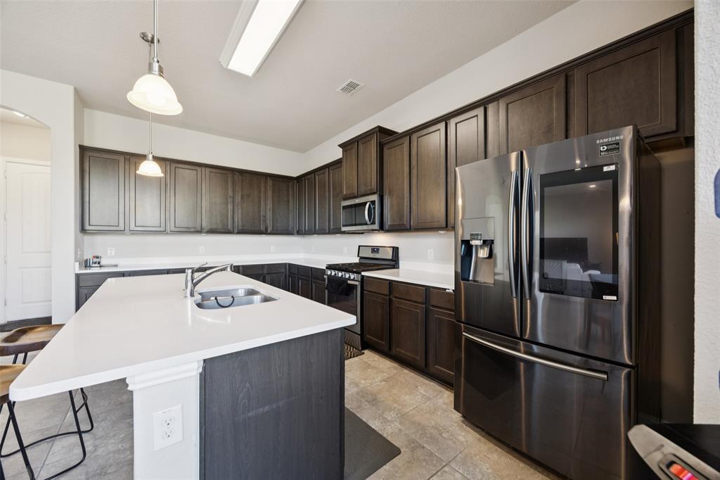 1701 Long Meadow Road Wylie, TX 75098 - Photo 7 of 30 a kitchen with stainless steel appliances granite countertop a refrigerator sink and stove