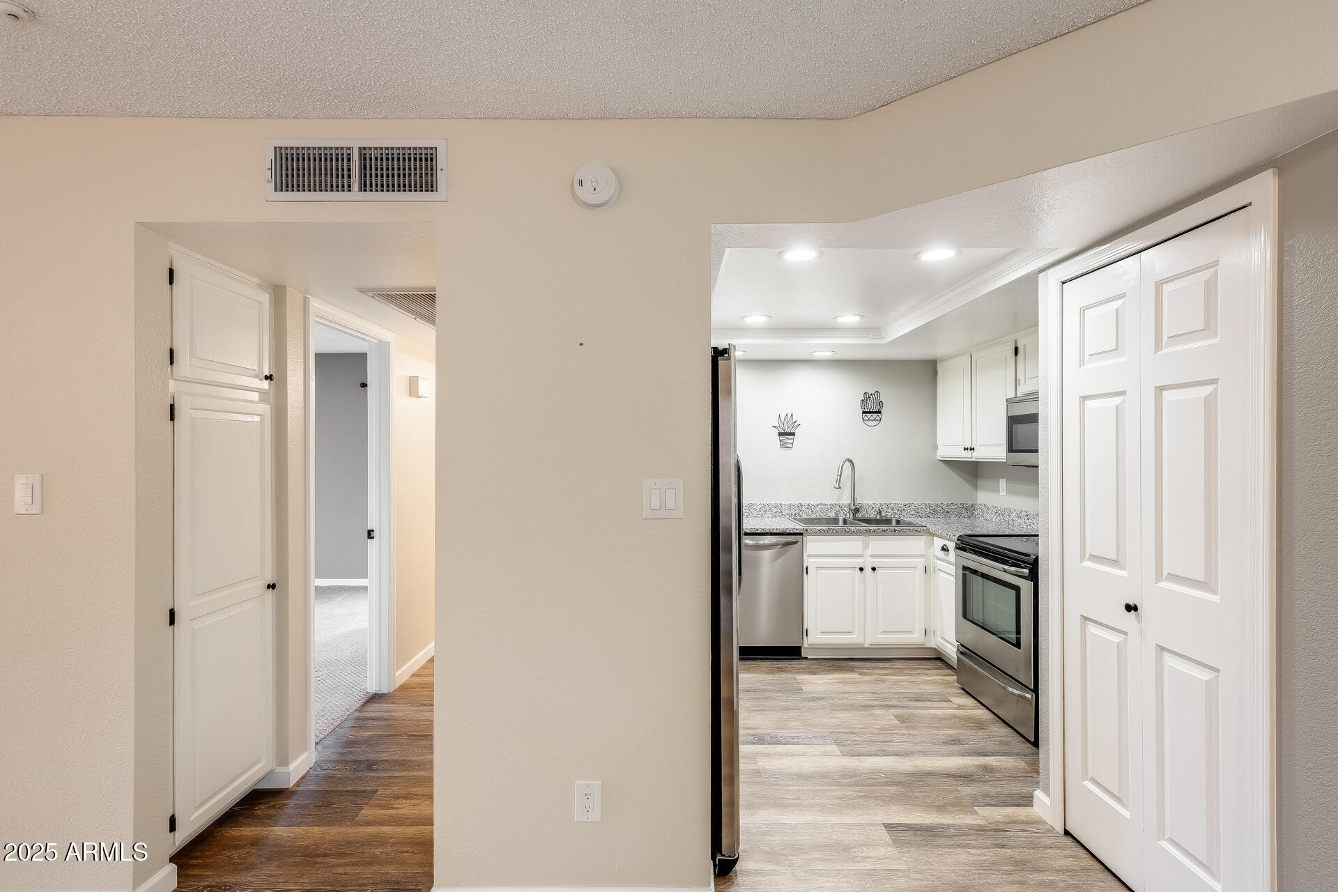 9151 West Greenway Road, Unit 111 Peoria, AZ 85381 - Photo 20 of 45 a kitchen with stainless steel appliances granite countertop a refrigerator and a stove top oven
