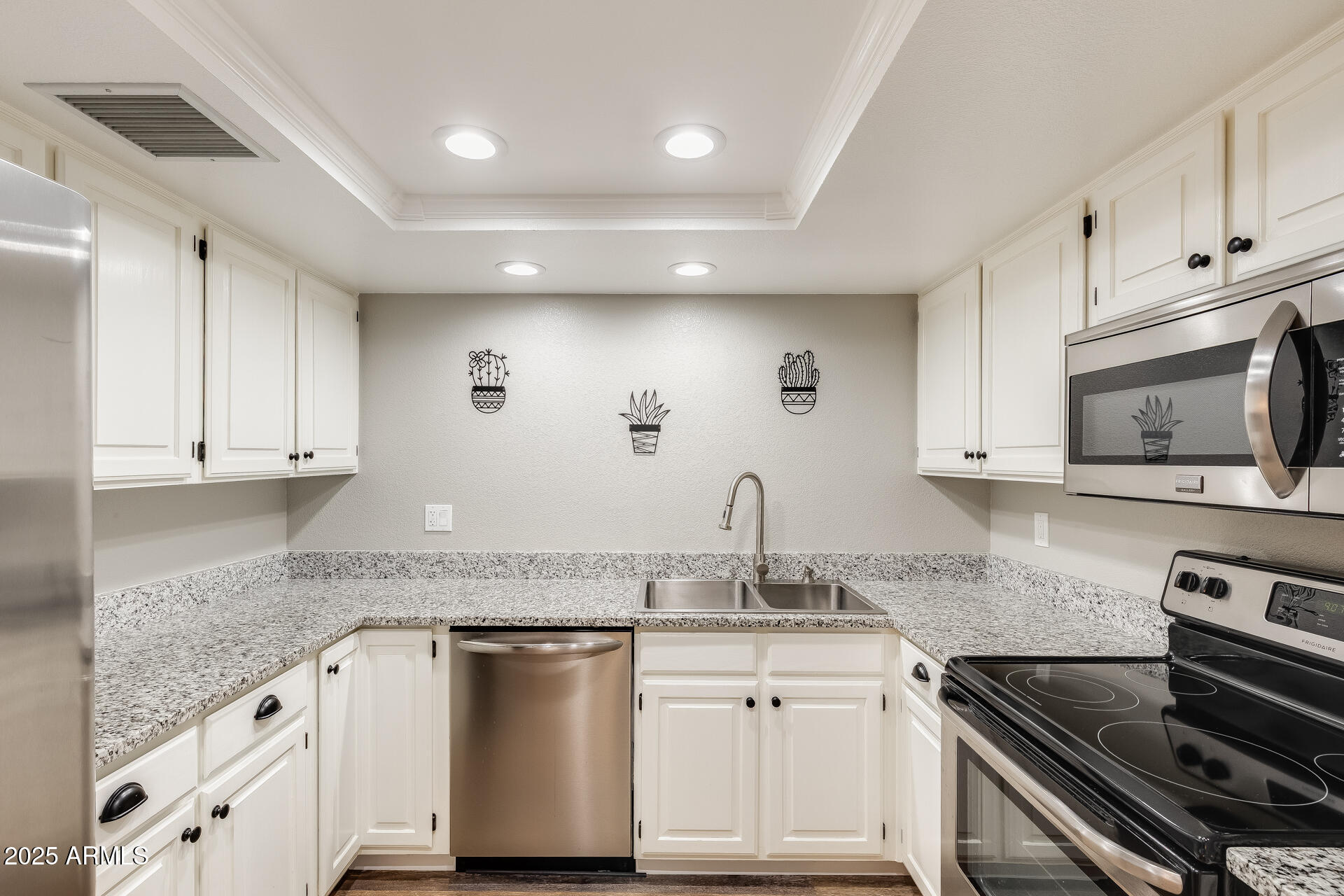 9151 West Greenway Road, Unit 111 Peoria, AZ 85381 - Photo 21 of 45 a kitchen with granite countertop a sink stainless steel appliances and white cabinets