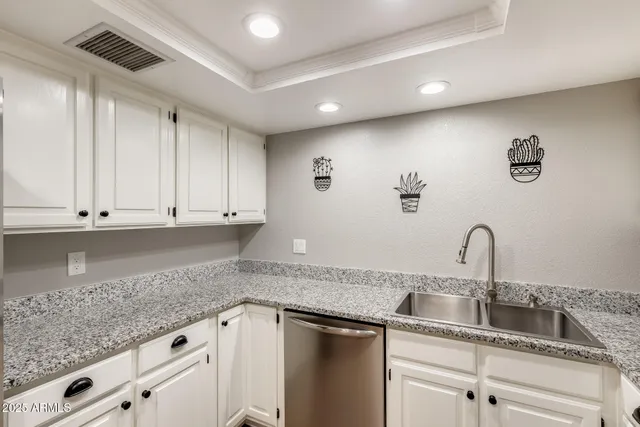a kitchen with granite countertop a sink and cabinets