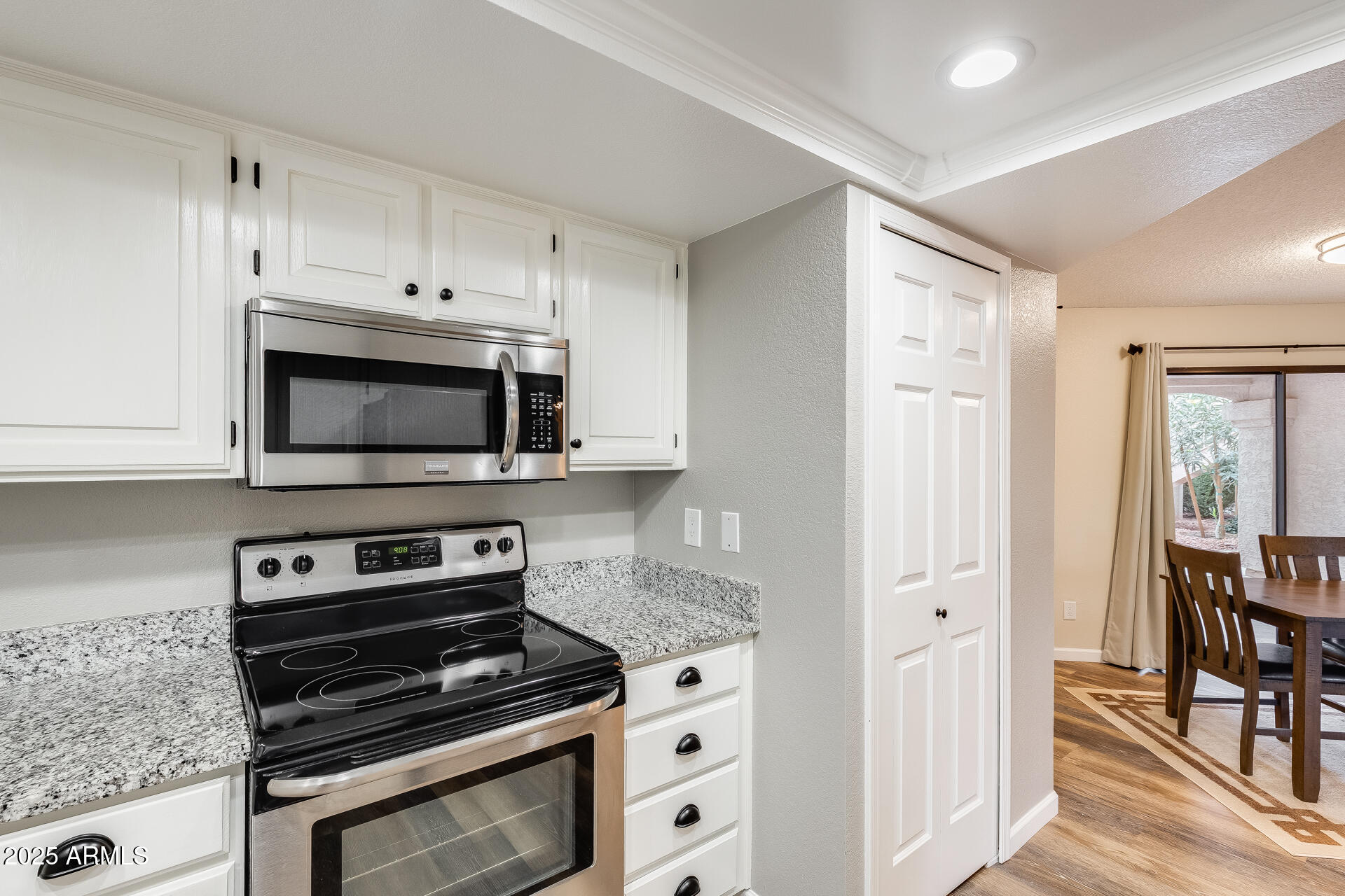 9151 West Greenway Road, Unit 111 Peoria, AZ 85381 - Photo 24 of 45 a kitchen with stainless steel appliances a stove a microwave and cabinets