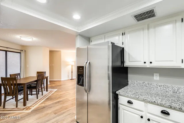 a kitchen with stainless steel appliances granite countertop a refrigerator and a stove top oven