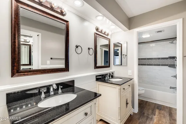 a bathroom with a granite countertop sink and a mirror