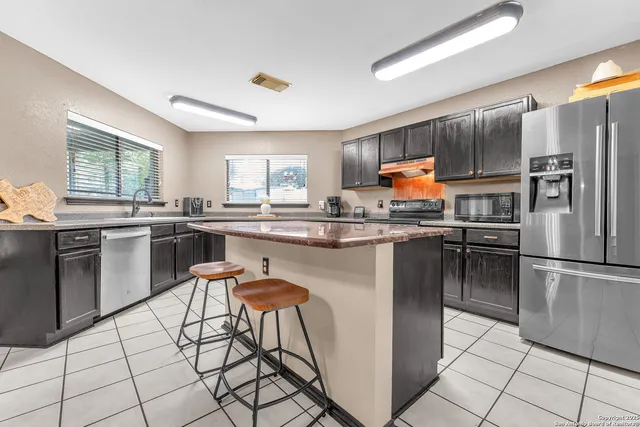 a kitchen with stainless steel appliances granite countertop a stove top oven a sink and cabinets