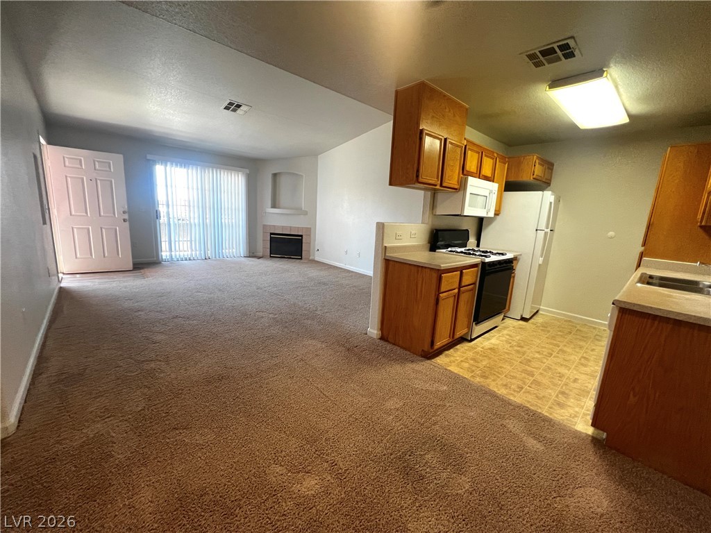 4730 East Craig Road, Unit 2104 Las Vegas, NV 89115 - Photo 2 of 20 An inviting open-plan living space offers seamless flow from kitchen to fire-warmed relaxation.