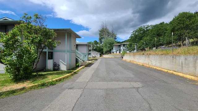 a view of a patio with a table and chairs under an umbrella next to a yard